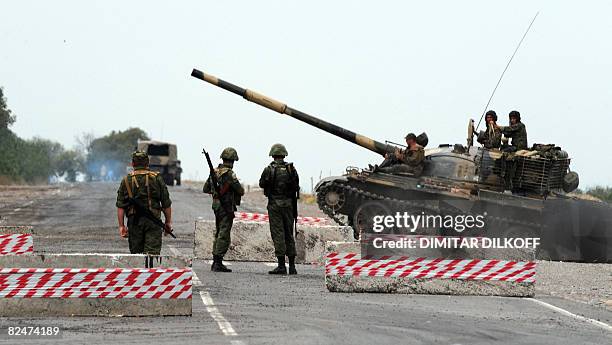 Russian soldiers looks at a tank passing at a checkpoint on the Gori-Tbilisi road near the village of Khurvaleti on August 20, 2008. Experts from...