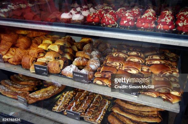 sweet baked items for sale in the window of a bakery in copenhagen, denmark - pain au chocolat stock-fotos und bilder