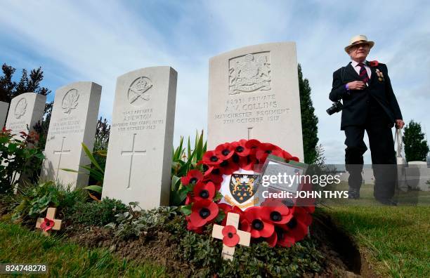 Visitor walks past headstones of soldiers who fell in World War One at The Tyne Cot Commonwealth War Graves Cemetery in Zonnebeke on July 31...