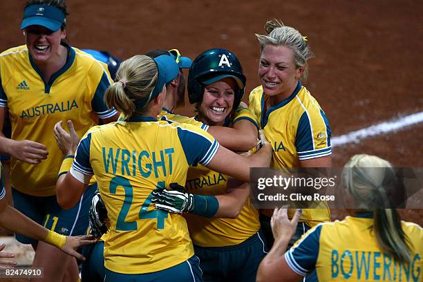 Kerry Wyborn of Australia celebrates with teammates Belinda Wright, Jodie Bowering and Danielle Stewart after Wyborn scored on a solo home run to tie...