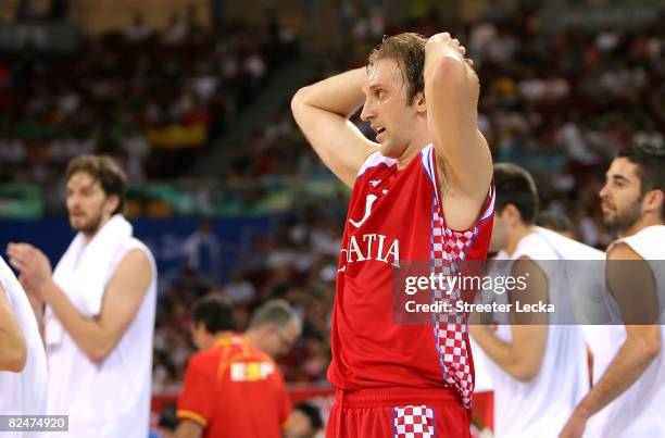 Zoran Planinic of Croatia walks off the court after Spain won the men's basketball quarterfinal game 72-59 at the Olympic Basketball Gymnasium during...