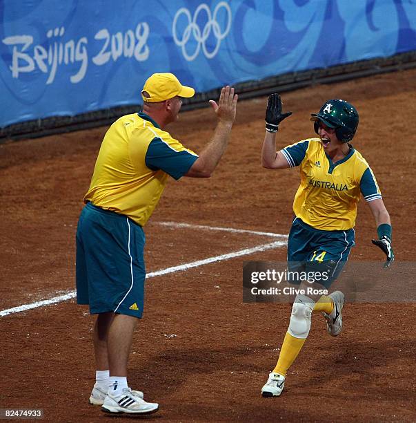 Kerry Wyborn of Australia celebrates with third base coach Richard McCreedy as Wyborn rounds third and heads home on a solo home run to tie the game...
