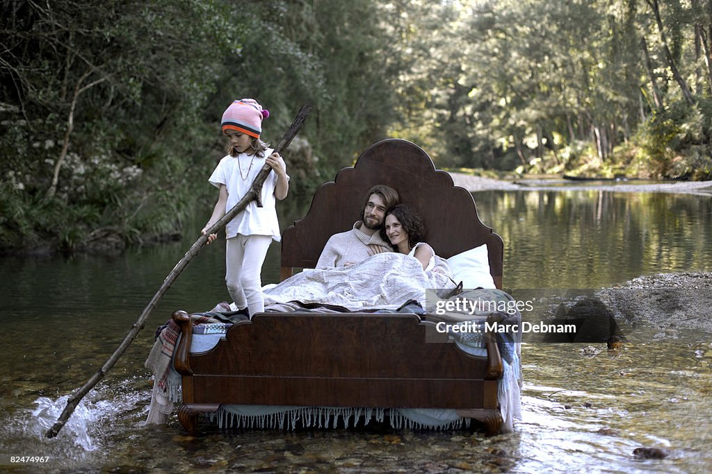 Family in bed, in water, like a raft