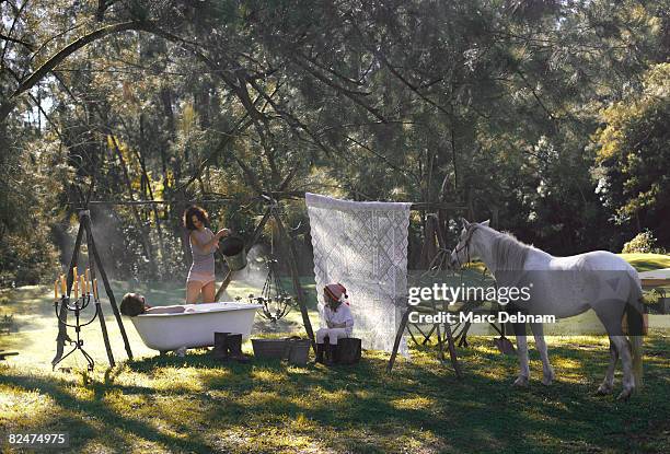 woman pours water into bath outdoors - australian light horse stock pictures, royalty-free photos & images