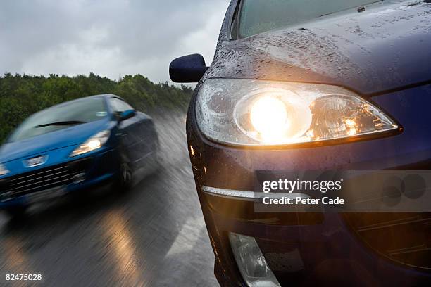 cars on motorway in the rain - car speeding stock-fotos und bilder