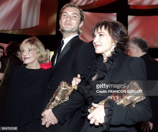 British actor Jude Law and French actress Marlene Jobert pose with their Cesar of honnor next to French actress Jeanne Moreau at the end of the 32nd...