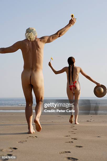 naked man and woman running on beach - beach bum fotografías e imágenes de stock