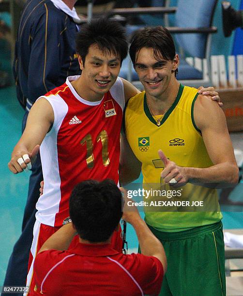 Yu Dawel of China pose with Gilberto Godoy Filho of Brazil after their men's quarterfinal volleyball match against China at the 2008 Beijing Olympic...