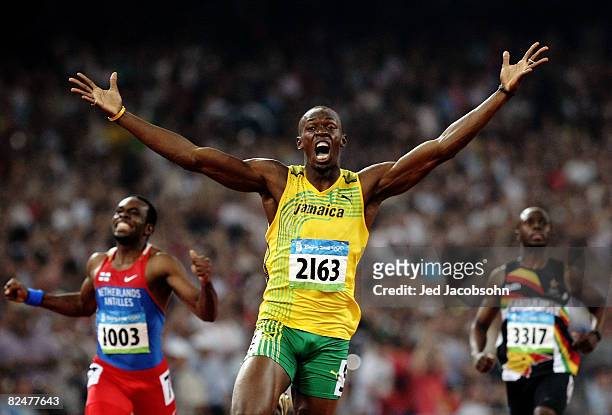 Usain Bolt of Jamaica reacts after breaking the world record with a time of 19.30 to win the gold medal as Churandy Martina of Netherlands Antilles...