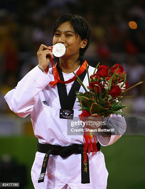Silver medalist Buttree Puedpong of Thailand poses on the podium after the presentation ceremony for the Women's taekwondo -49kg at the University of...