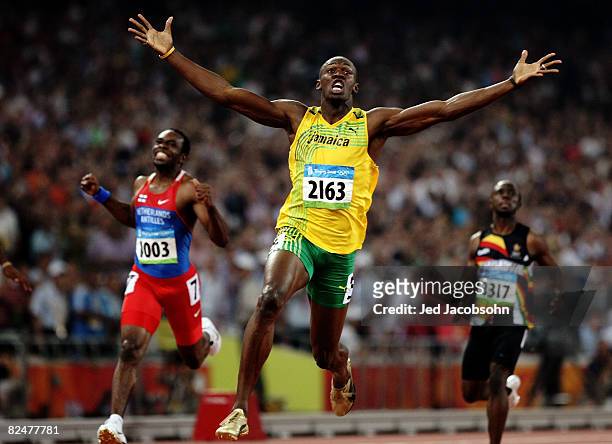 Usain Bolt of Jamaica reacts after breaking the world record with a time of 19.30 to win the gold medal as Churandy Martina of Netherlands Antilles...