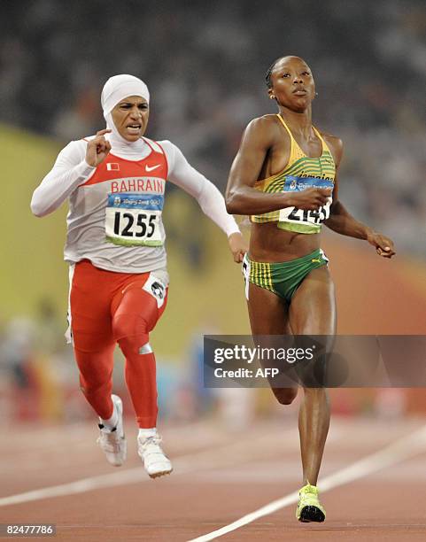 Bahrain's Roqaya al-Gassra and Jamaica's Sherone Simpson compete in the women's 200m semi-final 2 at the "Bird's Nest" National Stadium during the...