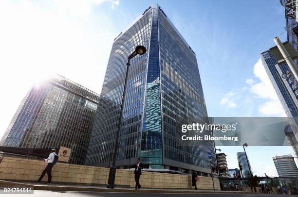 Pedestrians pass 30 Churchill Place, centre, which houses the European Medicines Agency, in the Canary Wharf financial, business and shopping...