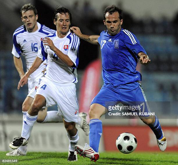 Theofanis Gekas of Greece shoots a goal in front of Slovakia's Marek Cech and Jan Durica during a friendly match on August 20, 2008 in Bratislava....