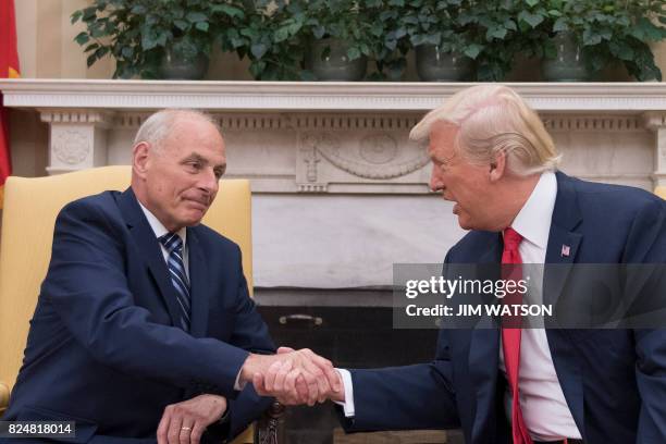 President Donald Trump shakes hands with newly sworn-in White House Chief of Staff John Kelly at the White House in Washington, DC, on July 31, 2017....