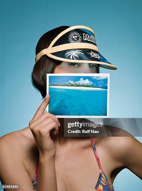 portrait of female holding picture of beach - postkarte stock-fotos und bilder