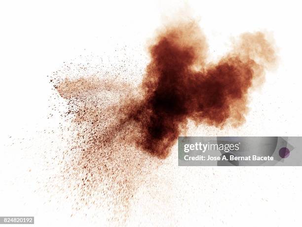 forms and textures of an explosion of a powder of color brown on a white background - castanho imagens e fotografias de stock