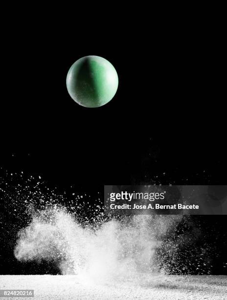 impact and rebound of a ball   on a surface of land and powder on a black background - balls bouncing stock pictures, royalty-free photos & images