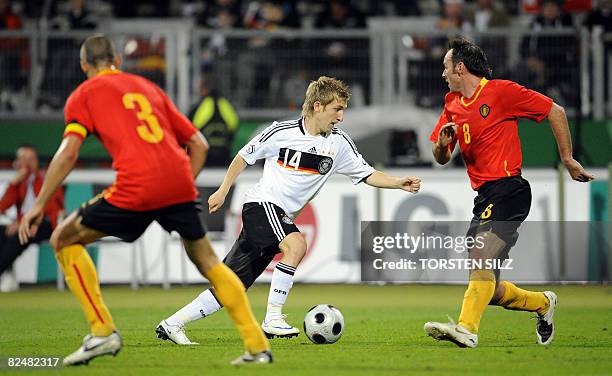 Germany's midfielder Marko Marin plays the ball past Belgium's Timmy Simons and Bart Goor to score during the friendly international football match...