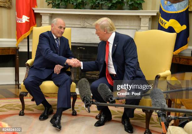 President Donald Trump shakes hands with new White House Chief of Staff John Kelly after he was sworn in, in the Oval Office of the White House, July...
