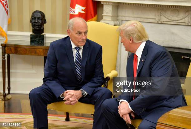 President Donald Trump speaks to new White House Chief of Staff John Kelly after he was sworn in, in the Oval Office of the White House, July 31,...