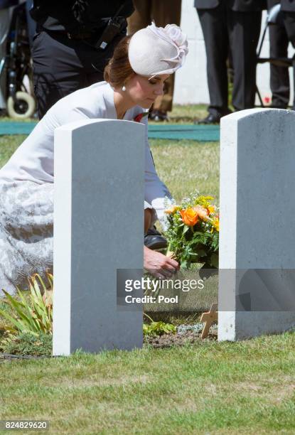 Catherine, Duchess of Cambridge lays a posy at the grave of an unknown soldier during a ceremony at the Commonwealth War Graves Commisions's Tyne Cot...