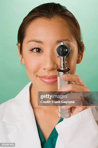 doctor with otoscope covering one  - otoscope fotografías e imágenes de stock