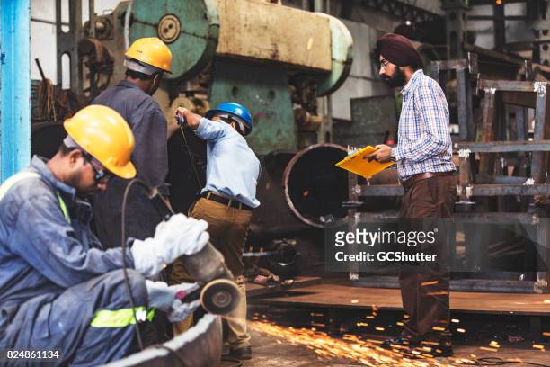 factory supervisor monitoring the progress of several projects - india stock pictures, royalty-free photos & images