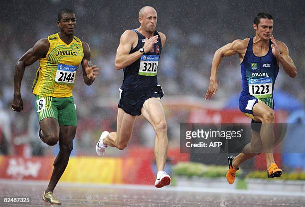 Maurice Smith of Jamaica, Tom Pappas of the US and Carlos Chinin of Brazil compete during the men's decathlon 100m heats at the National Stadium in...