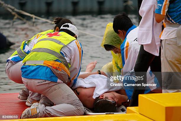 Silver medalist David Davies of Great Britain requires medical attention after he collapse following the finish of the men's marathon 10km swimming...