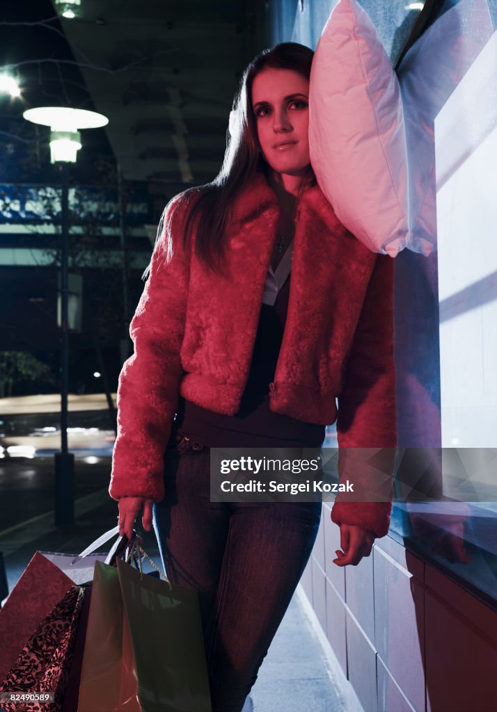 Young woman resting on pillow at night on urban st