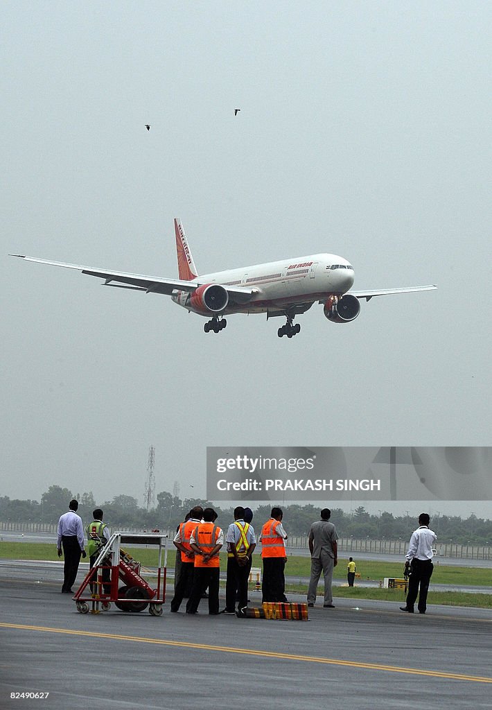 Indian groundstaff look on as a special
