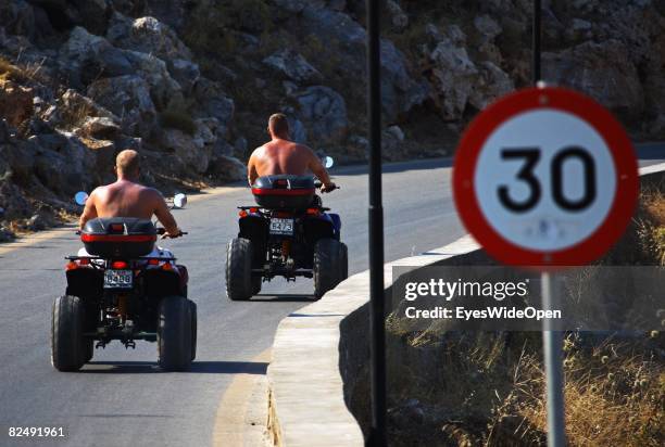 Tourists on a quad motorbike along Landscape and coastline near the village Lindos on August 08, 2008 in Rhodes, Greece. Rhodes is the largest of the...