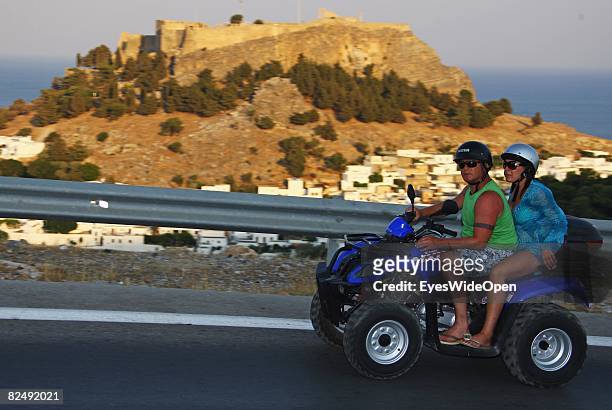 Tourists on a quad motorbike along Landscape and coastline near the village Lindos on August 08, 2008 in Rhodes, Greece. Rhodes is the largest of the...