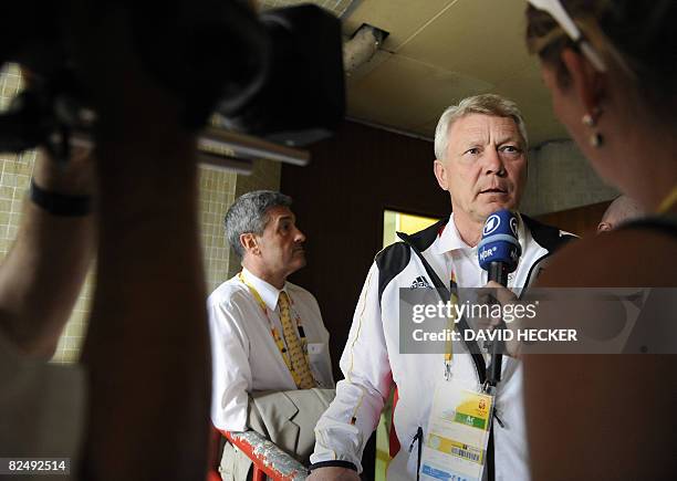 The head of the German show jumping committee, Peter Hofmann , looks on as Reinhard Wendt , chef de mission for the German equestrian team, speaks to...