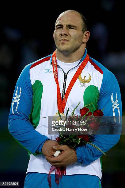 Artur Taymazov of Uzbekistan stands on the podium after winning the gold medal in the men's 120 kg wrestling gold medal match held at the China...