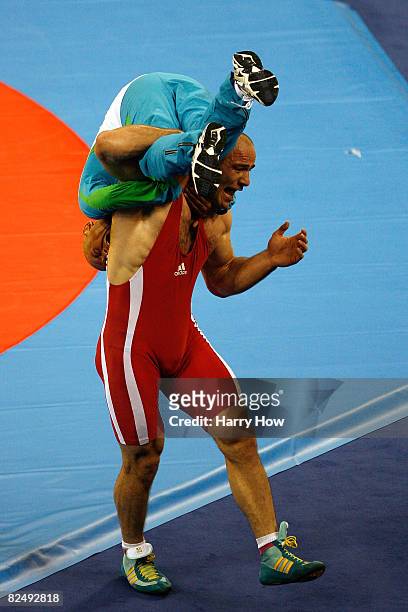 Artur Taymazov of Uzbekistan picks up his coach after winning the gold medal in the men's 120 kg wrestling gold medal match held at the China...