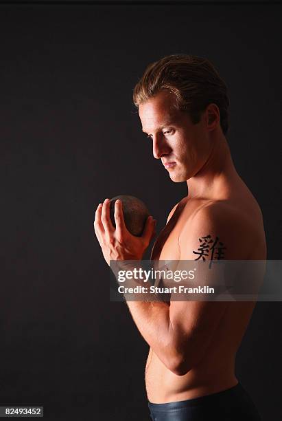 Olympic decathlete Andre Niklaus is seen with his Chinese Zodiac sign Rooster during a photo session on July 3, 2008 in Berlin, Germany.