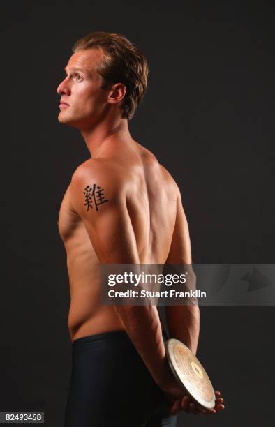 Olympic decathlete Andre Niklaus is seen with his Chinese Zodiac sign Rooster during a photo session on July 3, 2008 in Berlin, Germany.