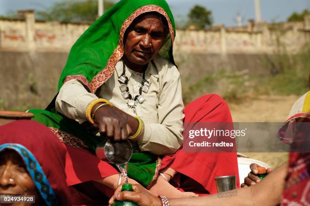 women in solidarity act provides water to another - water scarcity stock pictures, royalty-free photos & images