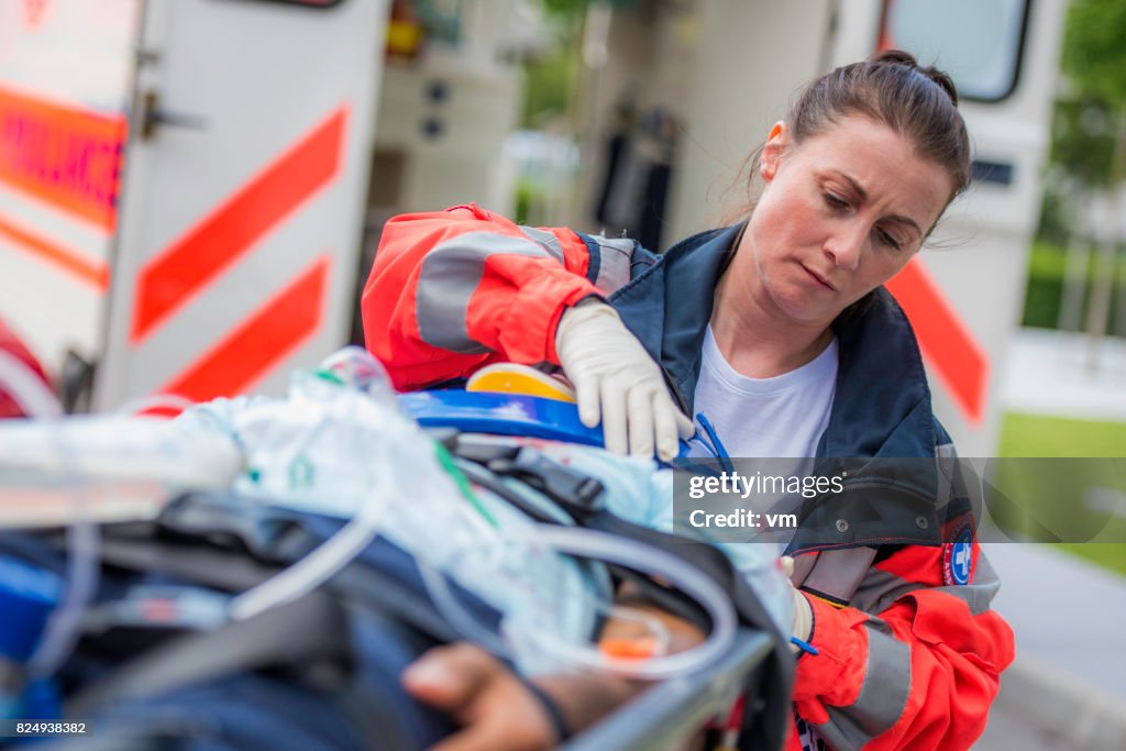 Weibliche Rettungssanitäter mit Patienten
