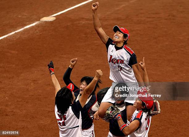 Yukiko Ueno of Japan and her teammates celebrate Japan's 3-1 win against the United States during the women's grand final gold medal softball game at...