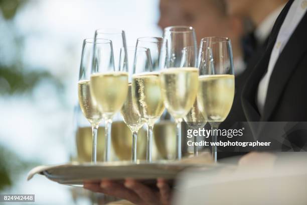 servieren von champagner auf party - champagneglas stock-fotos und bilder