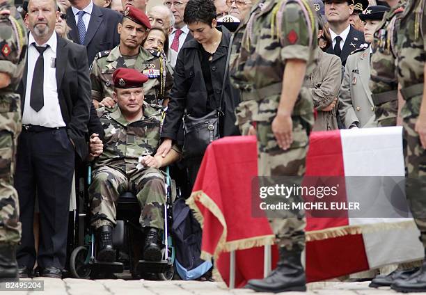 An unidentified soldier, sitted in a wheelchair, attends at Les Invalides, in Paris, on August 21 the funeral ceremony for the 10 French soldiers...