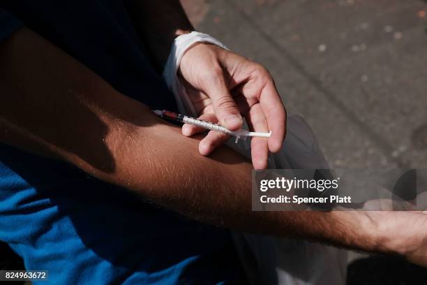 Man shoots-up by a railway underpass in the Kensington section of Philadelphia which has become a hub for heroin use on July 31, 2017 in...