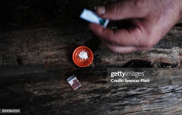 Chris, a homeless heroin addict, mixes cocaine and heroin near a railway underpass in the Kensington section of Philadelphia which has become a hub...