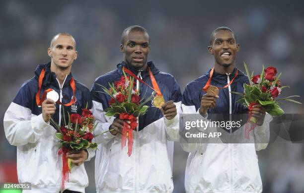LaShawn Merritt of the United States poses with his gold medal with compatriots silver medalist Jeremy Wariner and bronze medalist David Neville on...