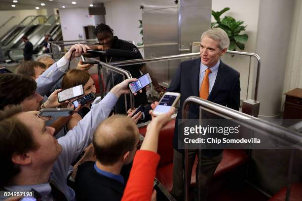 Sen. Rob Portman continues to talk to reporters after boarding the Senate subway following a vote at the U.S. Capitol July 31, 2017 in Washington,...
