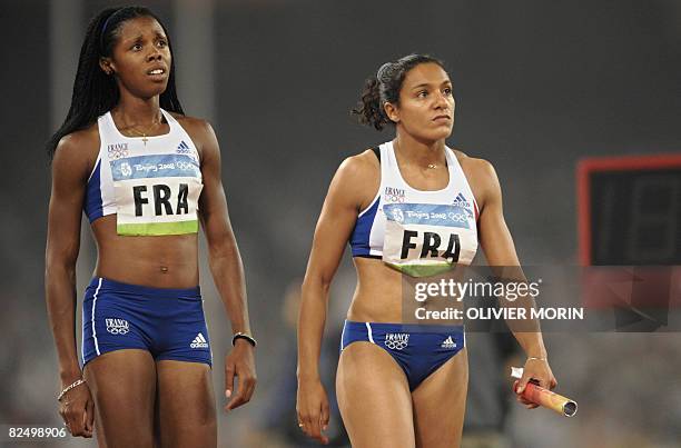 France's Carima Louami and Lina Jacques Sebastien converse following the women's first round 4x100m relay at the "Bird's Nest" National Stadium...