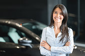 Happy woman buying a car at the dealership